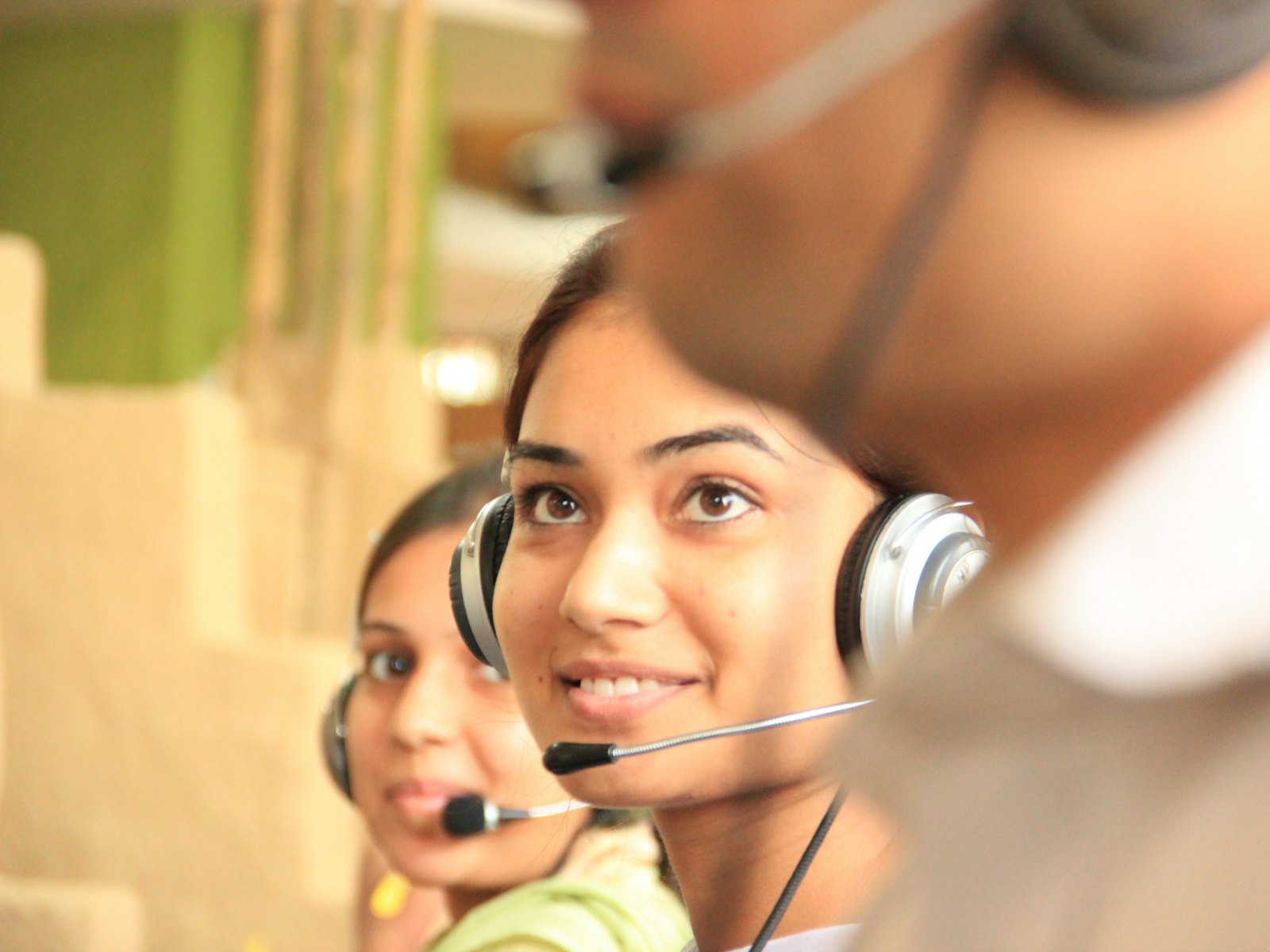 An intake coordinator wearing a headset, smiling while taking a call